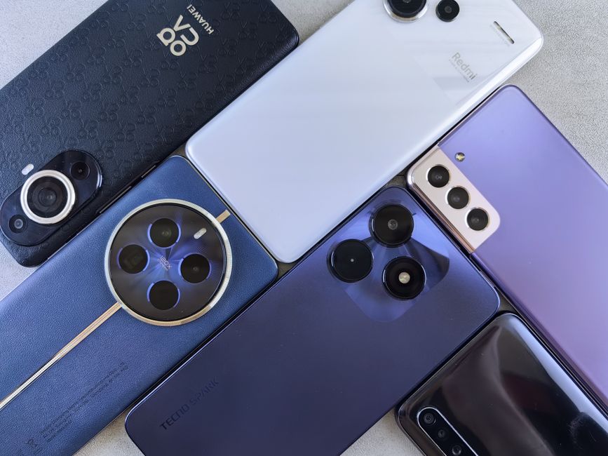Top view of various modern smartphones showcasing diverse camera designs on flat surface.